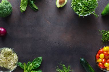 Çerçeve kümesinden Detoks salata koyu arka plan üzerinde için malzemeler. Brokoli, ıspanak, avokado, roka, bezelye çekimleri, yonca, soğan, domates ve salatalık karanlık yüzey, en iyi görünüm