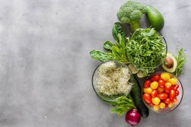 Malzemeler için Detoks salata kenarlıklı beyaz arka plan üzerinde kümesi. Brokoli, ıspanak, avokado, roka, bezelye çekimleri, yonca, kireç, soğan, domates ve salatalık beyaz yüzey, en iyi görünüm