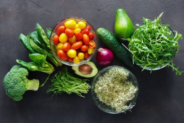 Detoks salata için malzemeler kümesi. Brokoli, ıspanak, avokado, roka, bezelye çekimleri, yonca, soğan, domates ve salatalık gri, en iyi görünüm