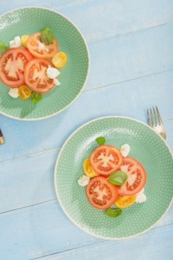 Rustik tarzı. Domates ve mozzarella peyniri mavi ahşap masa, üstten görünüm üzerinde İtalyan salatası