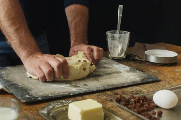 Male hands knead the dough for cooking cross buns in a home kitchen