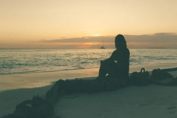 Νεαρή Γυναίκα Κάθεται Στην Παραλία Και Απολαμβάνοντας Ηλιοβασίλεμα — Φωτογραφία Αρχείου