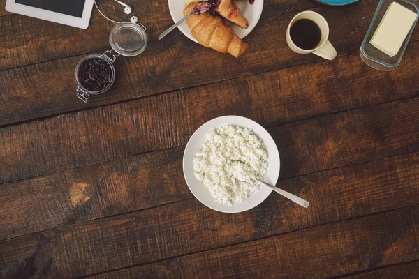 健康的な朝食のコンセプトです 最大ではクロワッサンとコーヒーと木製のテーブルにジャムとバターの皿 — ストック写真
