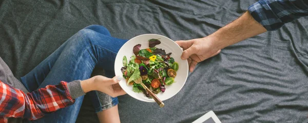 男人把沙拉放在床上给心爱的女人 爱与关怀的概念 — 图库照片