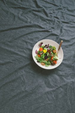 Yaz salatası sebze, çiçek nasturtium ve menekşe ile bardak limonata yatakta