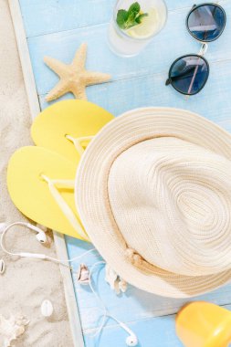Seyahat aksesuarları ayarlayın. Hasır şapka, güneş gözlüğü, flip flop, kokteyl, güneş kremi, kulaklıklar. Seyahat tatil kavramı. Yaz arka plan