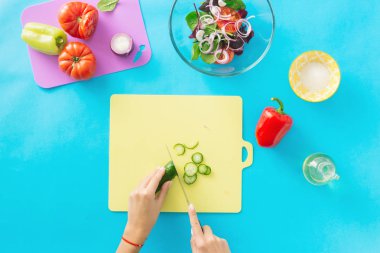 Kadın yemek bir yaz vejetaryen salata mavi bir arka plan üzerinde eller. Sağlıklı gıda kavramı. Diyet gıda