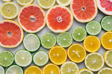 Dilimlenmiş narenciye meyve üstten görünüm ışık arka plan üzerine kapatın. Düz yatıyordu. Yaz arka plan