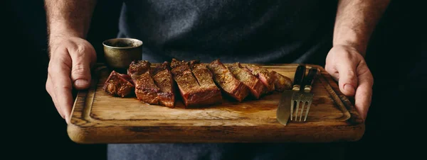 Muž Který Držel Šťavnaté Grilované Hovězí Steak Kořením Prkénku — Stock fotografie