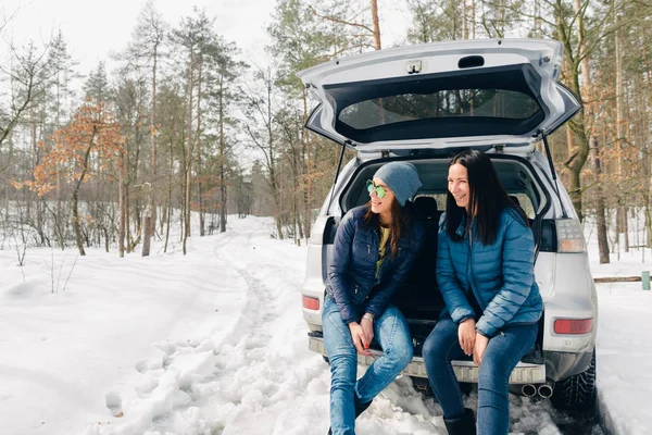 Dvě Mladé Ženy Sedící Kufru Auta Zimě Lese — Stock fotografie