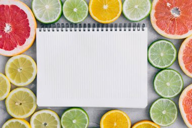 Defter dilimlenmiş narenciye meyve ile üstten görünüm açık renkli üzerinde