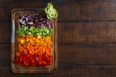 koyu arka plan üzerinde kesme tahtası üzerinde düzenlenmiş kıyılmış taze sebze