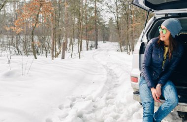 Araba gövde kış orman içinde oturan genç kadın