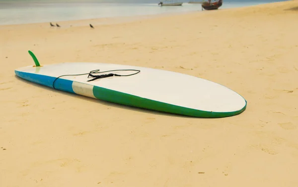 View of surfboard on sand beach at sunny day
