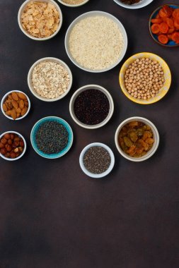 Üstten Görünüm vejetaryen sağlıklı yiyecekler - farklı superfood, tohum ve hububat kopya alanı ile koyu arka plan üzerinde ayarlayın. Düz yatıyordu. Temiz yemek kavramı