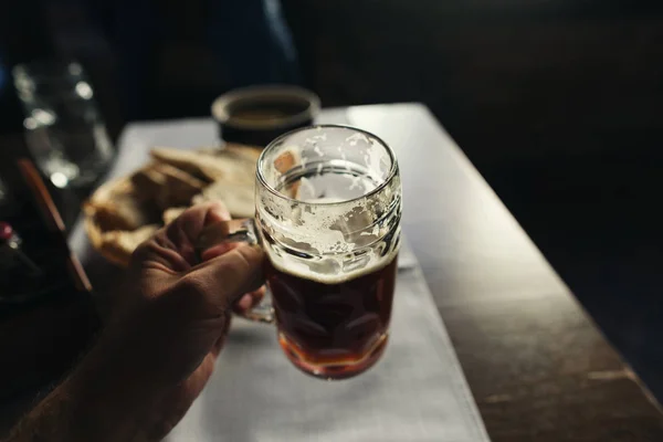 男性の手で新鮮な黒ビールのグラスをクローズ アップ — ストック写真