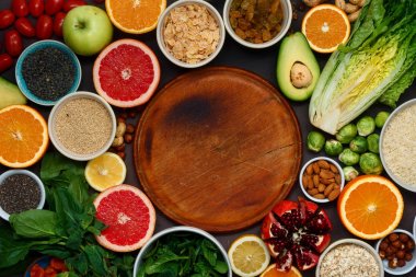 Ahşap mutfak kurulu temiz yemek ayarla. Sağlıklı gıda - farklı sebze ve meyve, superfood, tohumlar, tahıl, üzerinde koyu arka plan en iyi görünüm düz lay yaprak sebze vejetaryen