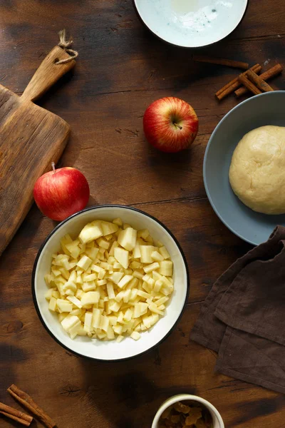 为苹果馅饼准备馅料的配料 木桌上的苹果 葡萄干 面团和肉桂 顶部视图 — 图库照片