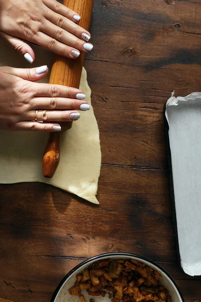 Руки женщины готовят яблочный штрудель — стоковое фото