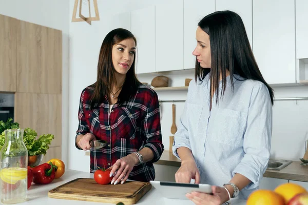 Amigos hablando y cocinando verduras — Foto de Stock