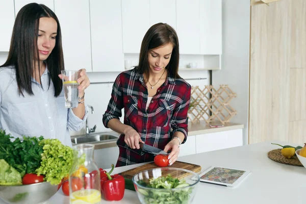 Amigos hablando y cocinando verduras — Foto de Stock
