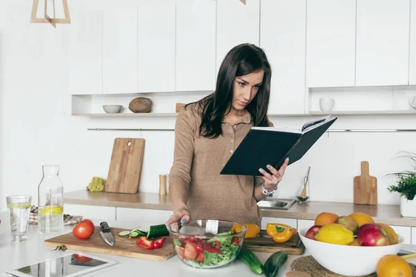 Mujer mirando receta ensalada de verduras —  Fotos de Stock