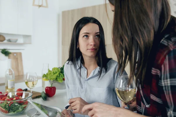 Dos novias hablando sentadas en la cocina casera — Foto de Stock