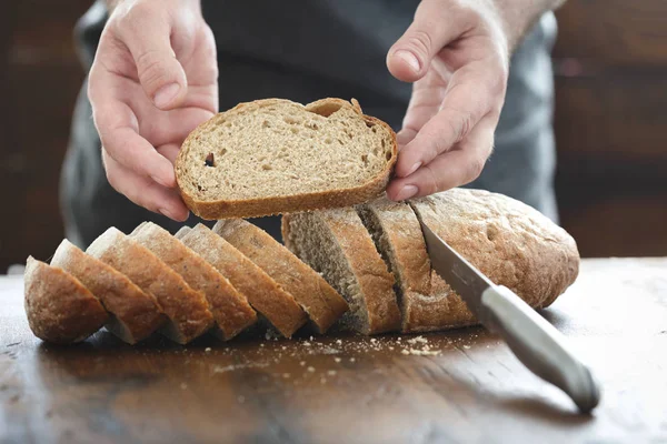Ręce, trzymając kromkę świeżego chleba — Zdjęcie stockowe