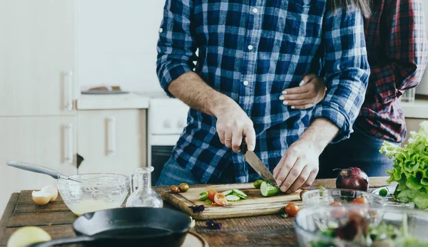 Couple preparing breakfast from vegetables at home in kitchen