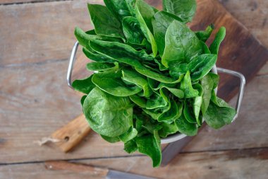 ahşap masa üzerinde taze yeşil demet ıspanak yaprakları