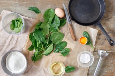 Ahşap masa üzerinde sağlıklı ıspanaklı krep yemek pişirmek için ham maddeler kümesi