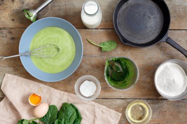 Ahşap masa üzerinde sağlıklı ıspanaklı krep yemek pişirmek için ham maddeler kümesi