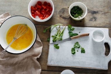 Sağlıklı kahvaltı kavramı. Domates ve yeşil ahşap masa, üstten görünüm, rustik tarzı ile hazırlık omlet için malzemeler