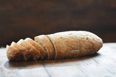 Taze ekmek ahşap bir masaya dilimlenmiş, düz görüntülemek