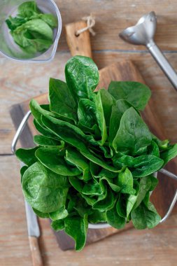 Ahşap masa üzerinde en iyi Görünümü Kapat sosu yapmak için blender ile taze demet ıspanak yaprakları