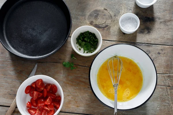トマトと緑の木製テーブル トップ ビューでオムレツを調理用食材 素朴なスタイル 健康的な朝食のコンセプト — ストック写真
