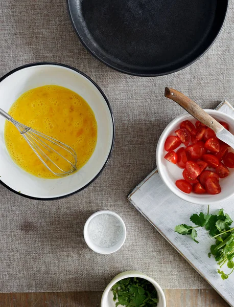 Ingredienser För Matlagning Omelett Med Tomater Och Grönska Träbord Ovanifrån — Stockfoto