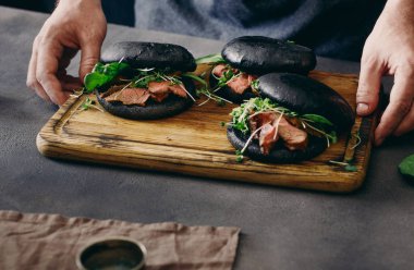 Mens holding ahşap tahta hamburger ile eller