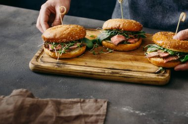 Mens holding ahşap tahta hamburger ile eller