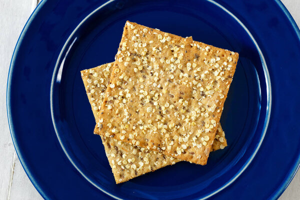 Dietary cookies with chia seeds on plate on white wooden background 