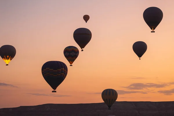 Many hot air balloons flight above mountains in Goreme national park, Cappadocia, Turkey