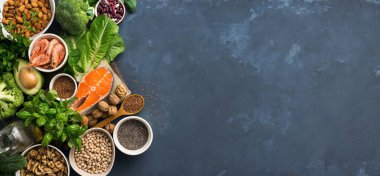 Omega 3 'ün besin kaynakları ve arka planda sağlıklı yağlar. Uzayı kopyala Sebzeler, deniz ürünleri, fındık ve tohum