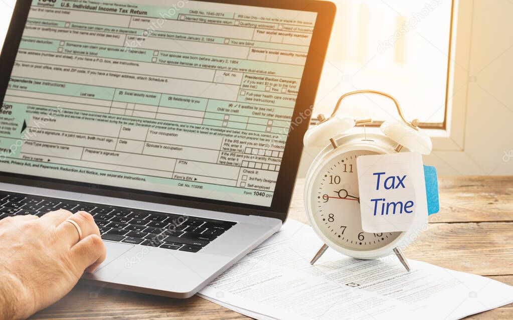 Tax time concept. Businessman hands fills individual income tax returns