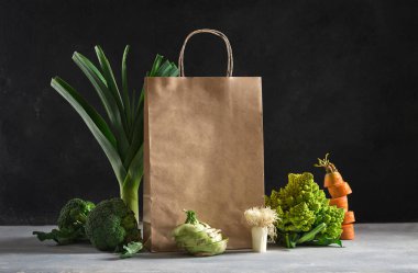 Koyu arka planda farklı sağlıklı yiyeceklerle dolu bir kese kağıdı. Süpermarket alışverişi ve beslenme planı konsepti