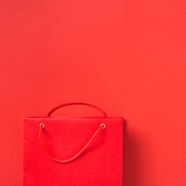Kırmızı arka plan üst görünümünde boş kırmızı kağıt torba