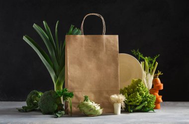 Koyu arka planda farklı sağlıklı yiyeceklerle dolu bir kese kağıdı. Süpermarket alışverişi ve beslenme planı konsepti