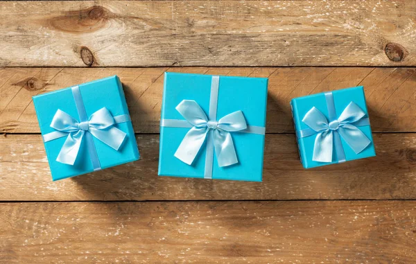Blauwe geschenkdozen linten op houten tafel bovenaanzicht — Stockfoto