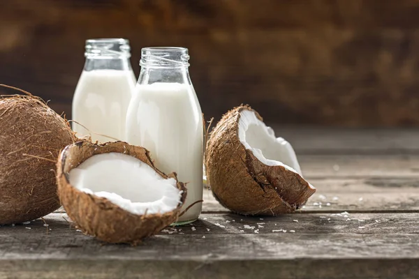 Ahşap masada cam şişede hindistan cevizi kefir. Vegan sütsüz, sağlıklı ya da mayalanmış içecek. Sağlıklı yeme kavramı