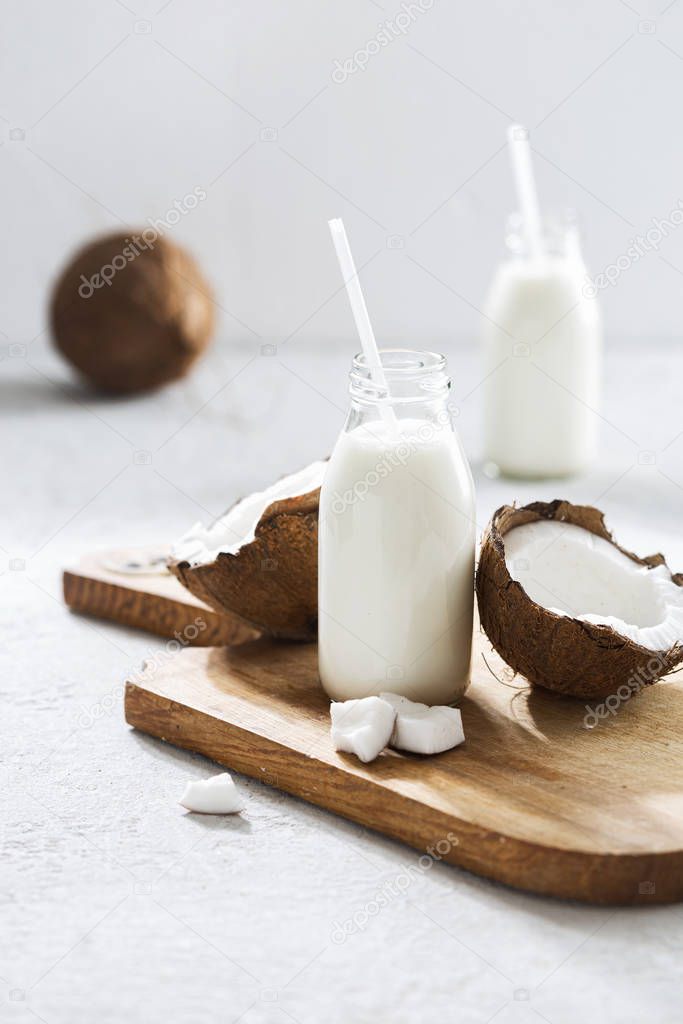 Coconut kefir in glass bottle on light background. Vegan non dairy healthy or fermented drink. Healthy eating concept
