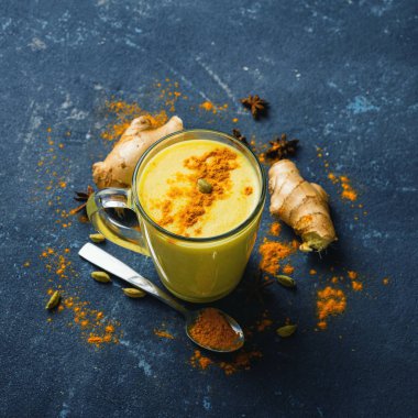 Siyah arkaplanda altın latte, fotokopi odası manzaralı. Sarı latte pişirmek için gerekli malzemeler